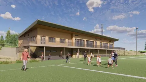 An architect's illustration showing what the new rugby clubhouse would look like. It is a two=-storey building made from wood and has a balcony extending along it. On the pitch are some children being coached, some people standing on the sidelines and a man running.