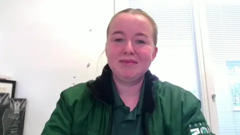 Diana Farrell. She has brown hair tied back, wearing a green polo shirt with green Dublin Zoo jacket.