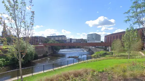 The Forge Island Canal area with a red bridge and greenery.