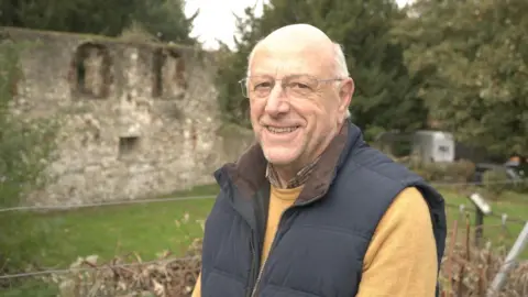 LDRS Philip Badman, secretary of Hallling Historical Society in front of last remaining wall of 12th Century Bishop's Palace in Halling