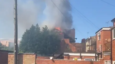 Damian Spencer Flames and smoke rising from a building roof