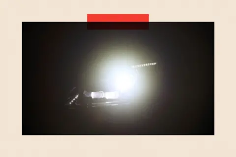 Bloomberg via Getty Images A car with bright headlights on