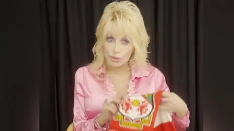 X Dolly Parton with a Wrexham FC scarf