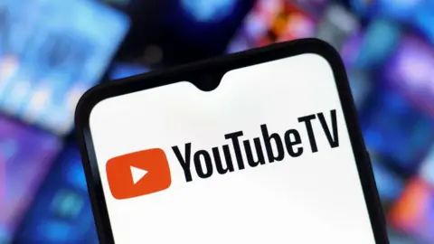 Getty Images A phone screen appears with a YouTube TV logo.