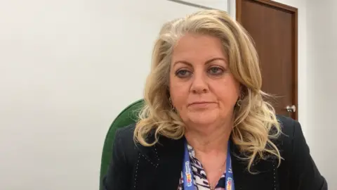 A woman with blonde hair in a black jacket