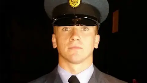 Family photo Corrie Mckeague wearing his grey military uniform, which includes a grey and black hat.