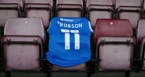 Getty Images Blue Robson football shirt on stadium seats