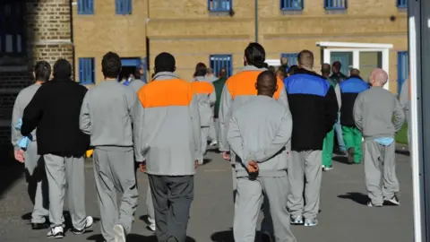 BBC Male prisoners seen from behind in the exercise yard of Wormwood Scrubs, a prison in London