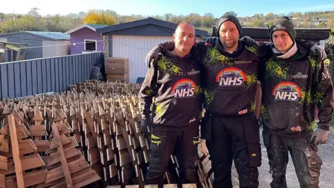 Martin, Reese and Nathan stood next to Christmas trees