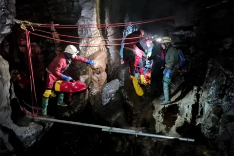 South and Mid Wales Cave Rescue Team Rescue team carrying injured caver on a stretcher through a cave, 8 November 2021