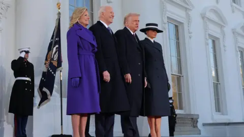 Joe and Jill Biden smile as they stand on the steps of the White House with the Trumps