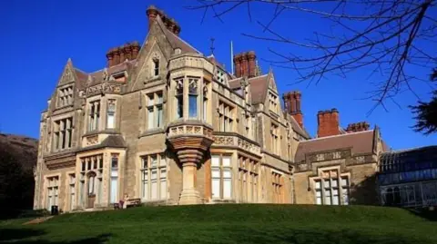 A big stone building on a hill against a bright blue sky