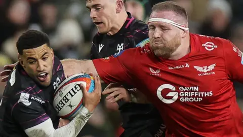 Keelan Giles of Ospreys is challenged by Henry Thomas