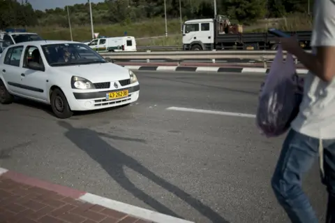 Geraldine Hope Ghelli A young Israeli boy hitches a ride at the Nahshon bus junction in Nahson, Israel