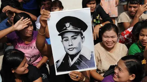 Getty Images Supporters of Aung San Suu Kyi hold aloft a portrait of her father, General Aung San, in 2012