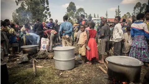 Getty Images Volunteers prepare meals for Internal displaced people, fleeing the recent clashes between M23 rebels and Congolese soldiers, at a camp in Kanyarushinya north of Goma