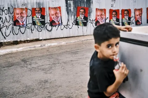 Getty Images Boy drinks cola in Brasilia with Lula posters behind