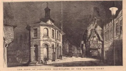 A black and white postcard image of Godalming.
