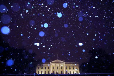 Reuters Snow is seen falling at night in front of the White House