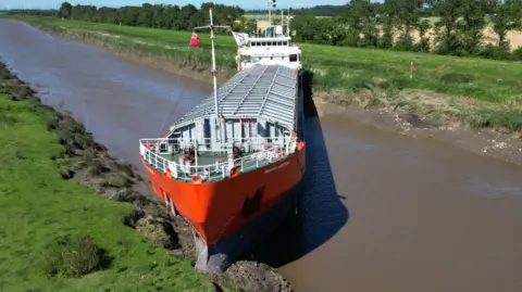  Steve Hubbard/BBC The Baltic Arrow grounded in the River Nene