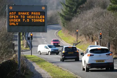 Getty Vehicles pass a warning sign at the entry to the A57 Snake Pass