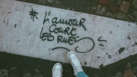 Unsplash Graffiti tag "L'amour court les rues" or "Love runs the streets"