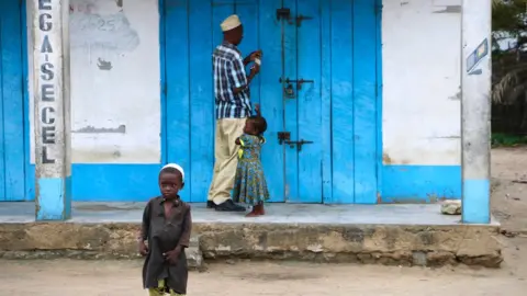 Getty Images A shop owner closes down his shop on March 7, 2018 in Mocimboa da Praia, Mozambique