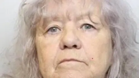 CPS A police mugshot of Christina Pomfret, who has shoulder length grey hair and blue eyes