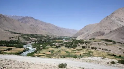 File gambar lembah Sangin di Afghanistan dengan latar belakang pegunungan gersang dan lembah subur di latar depan