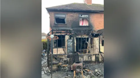 Derbyshire Fire Service A badly fire-damaged brick semi-detached house