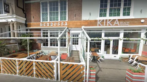 Google An exterior scene of the deserted Kika Beach bar with wooden outside seating