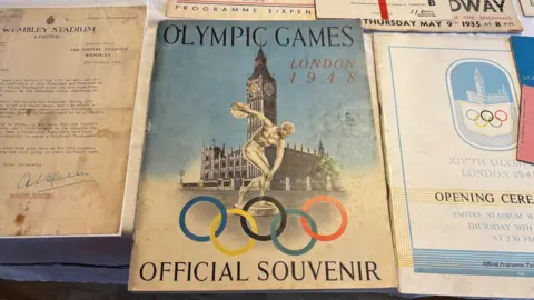 Items of Graham's collection were displayed on his kitchen table. This picture focuses on a programme from the 1948 London Olympics. 