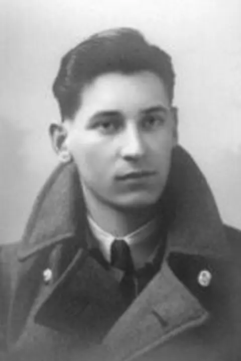 Bolton Family Black and white photo of Geoffrey Bolton aged 16. H has dark hair and an RAF overcoat on with high collar, he has a shirt and tie underneath.