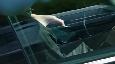 Man has mobile phone in hand while driving on the M25