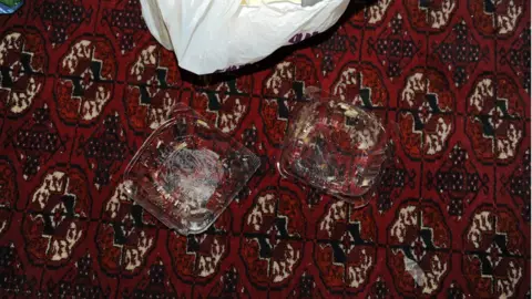 Police handout Pills and cake containers were discovered at the victim's home