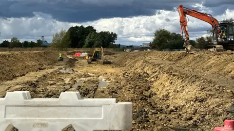 Two diggers work on digging a new canal trench