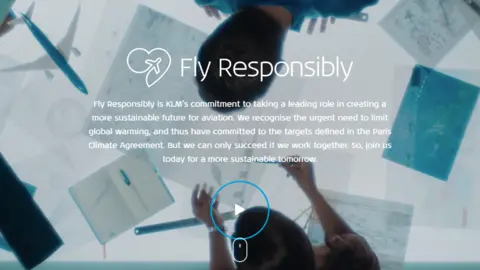 Screenshot/KLM Image shows two people leaning over board working on plans with 'Fly Responsibly' written over image