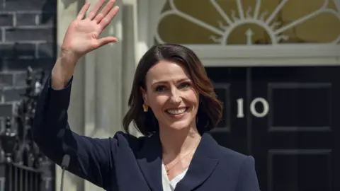 Netflix Suranne Jones as Abigail Dalton in Netflix's Hostage. She stands outside no10 downing street waving and smiling 