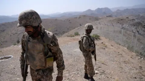 Getty Images Pakistani soldiers patrol next to a newly fenced border fencing along Afghan border at Kitton Orchard Post in Pakistan's North Waziristan tribal agency on October 18, 2017