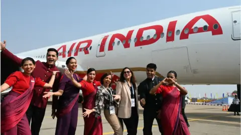 Getty Images Crew members pose next to India's first Airbus A350 of Air India airline