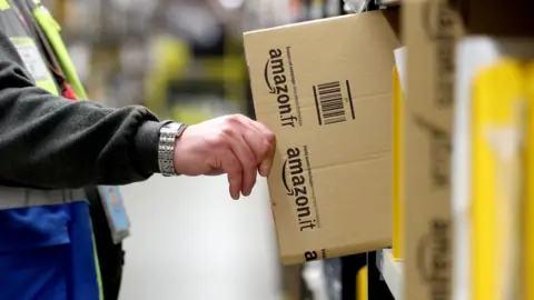 PA Media An Amazon worker collecting packaging at the Dunfermline fulfilment centre, Fife