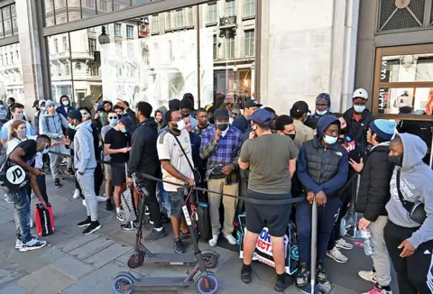 Getty Images A group of shoppers queue outside a Nike store in London