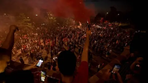 AFP/Getty Images Fans celebrate Liverpool winning the Premier League title