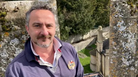 BBC A Reverend on top of a church roof