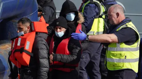 PA Media A group of people are brought in to Dover, Kent following a small boat incident in the Channel.