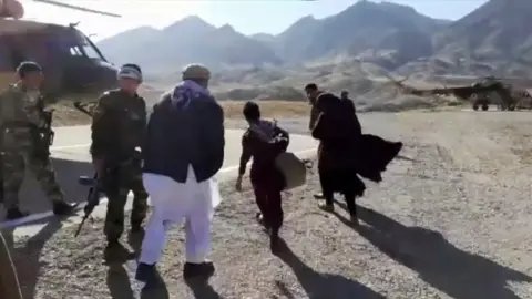 Local Afghan authorities Nooria and her two brothers boarding a military helicopter to a local safe house