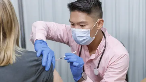 Getty Images Doctor giving vaccine