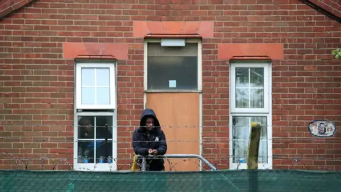 PA Media Asylum seeker watching a protest