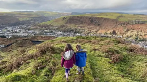 Clear South Wales' Coal Tips Phil Thomas's children walk on the coal tip near their home.