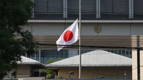 Getty Images De Japanse vlag wappert op 19 september 2024 halfstok buiten de Japanse ambassade in Peking.